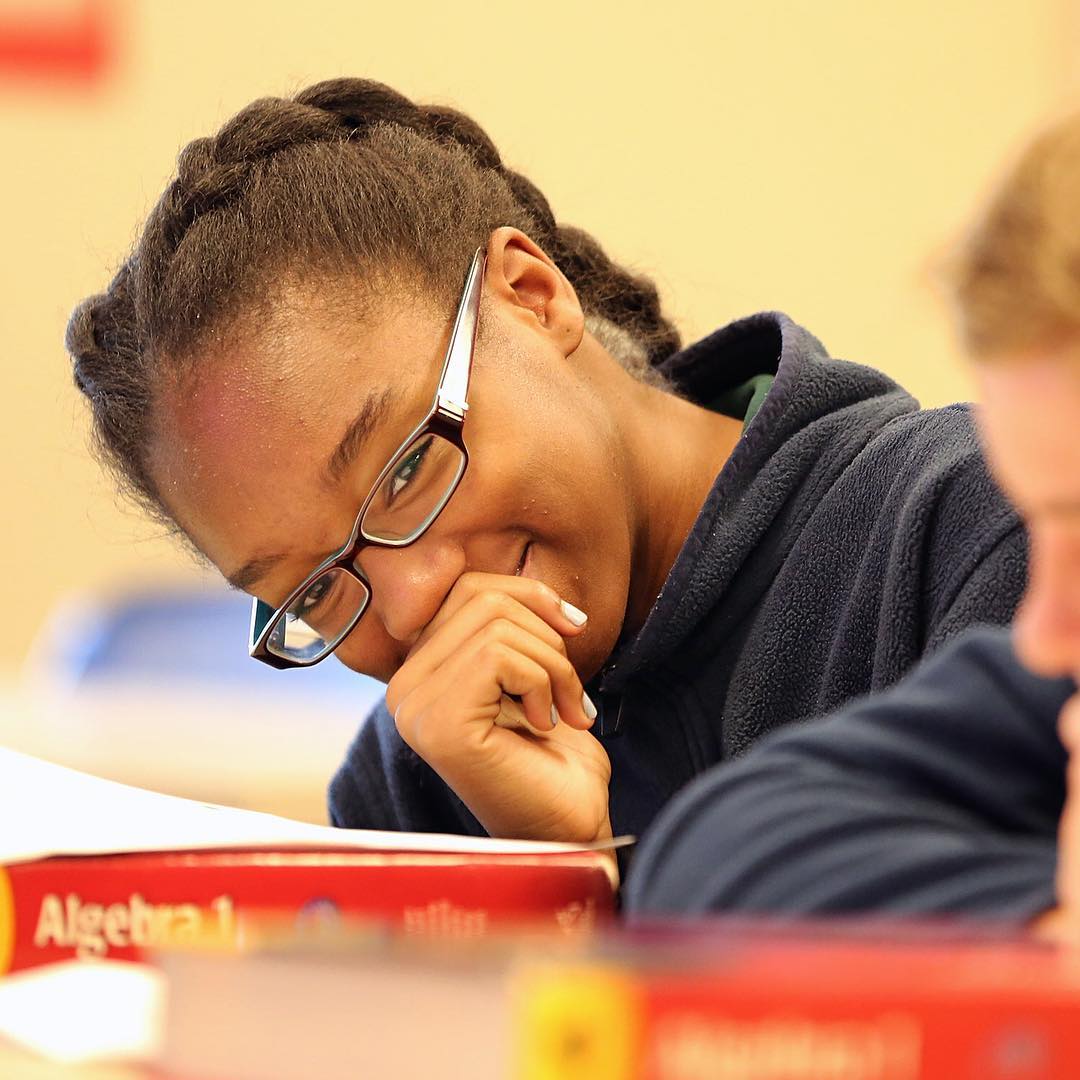 Eighth-grade students at ICS go over the syllabus for their Algebra I class