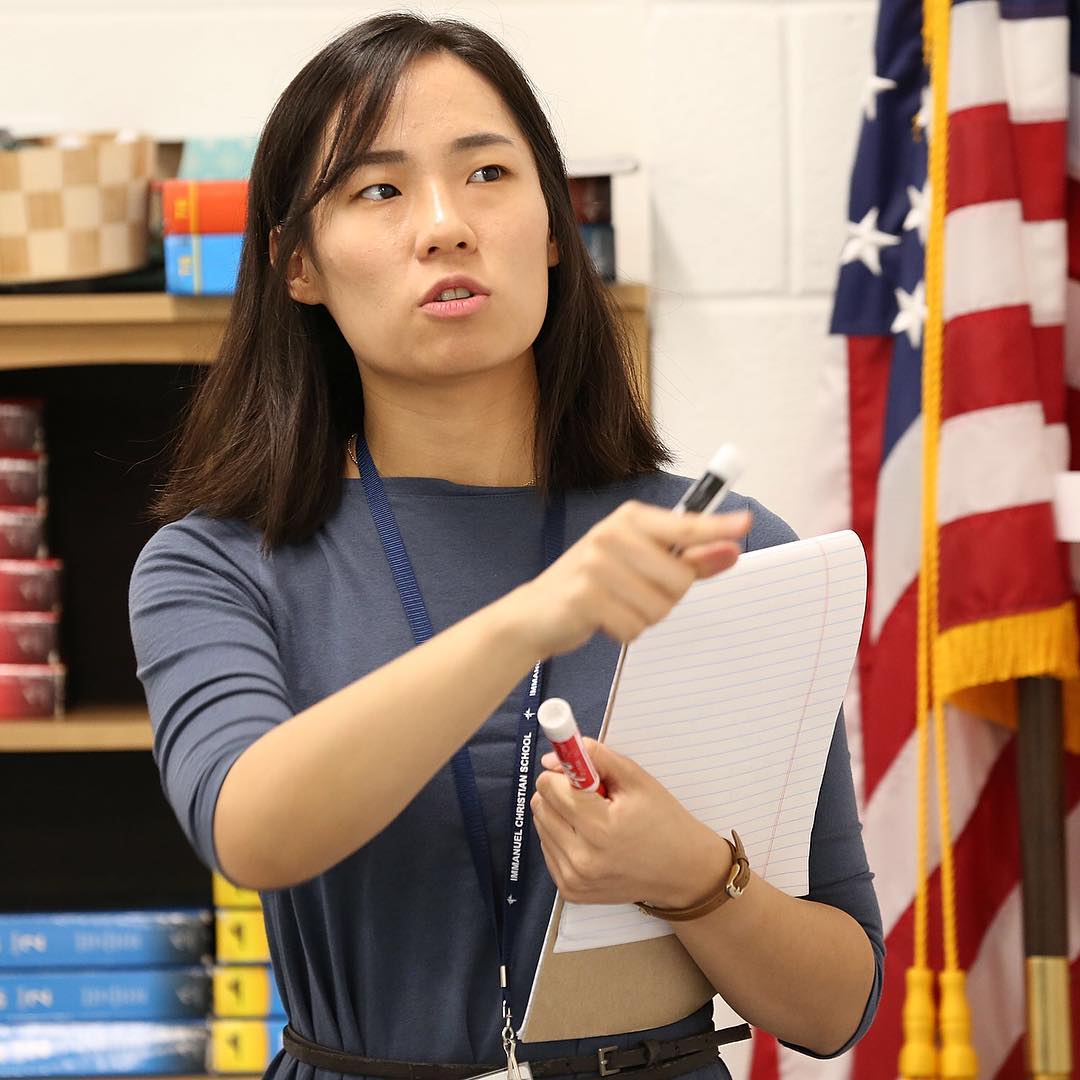 Youjin Suh explains the basics of constructing equations using exponents to her middle school students at ICS