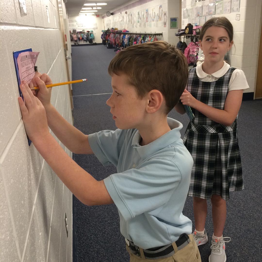 ICS students make notations from a hallway math project during extended classroom time